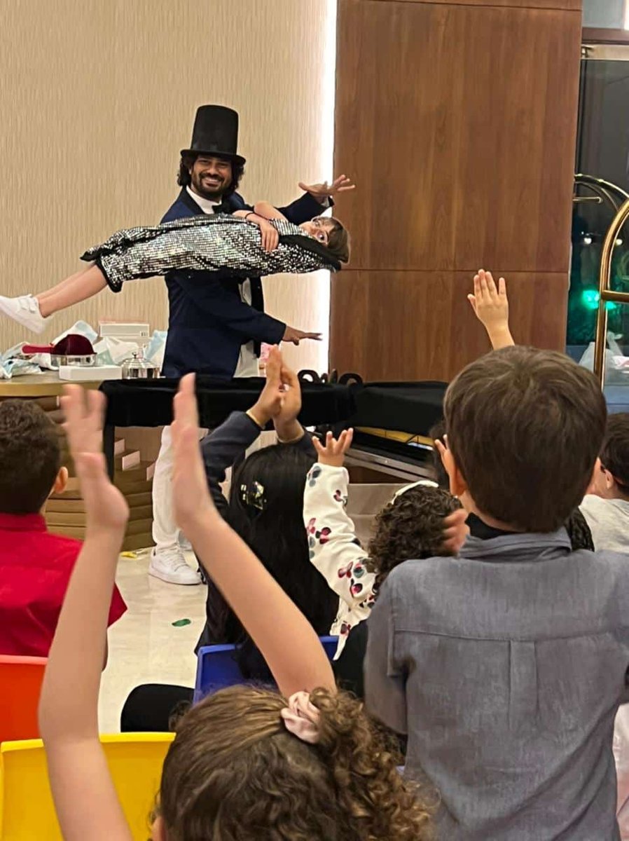 Magician entertaining excited children at a party in Singapore Magician entertaining excited children at a party in Singapore