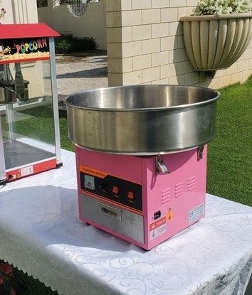 Pink candy floss machine set up on a table for event rental in Singapore