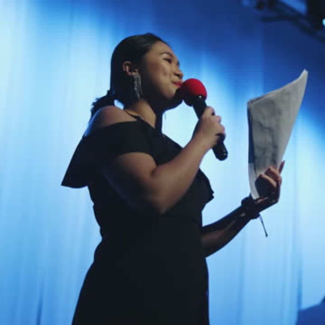 Event host speaking on stage in Singapore