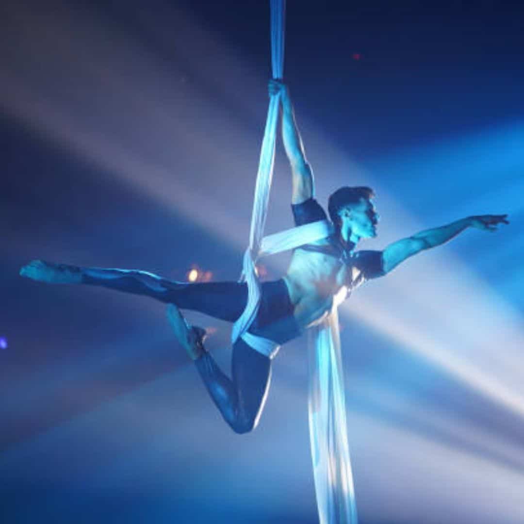 Aerial silk performer under blue lights in Singapore
