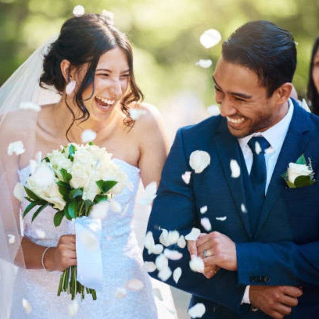 Bride and groom walking through flower petals in Singapore